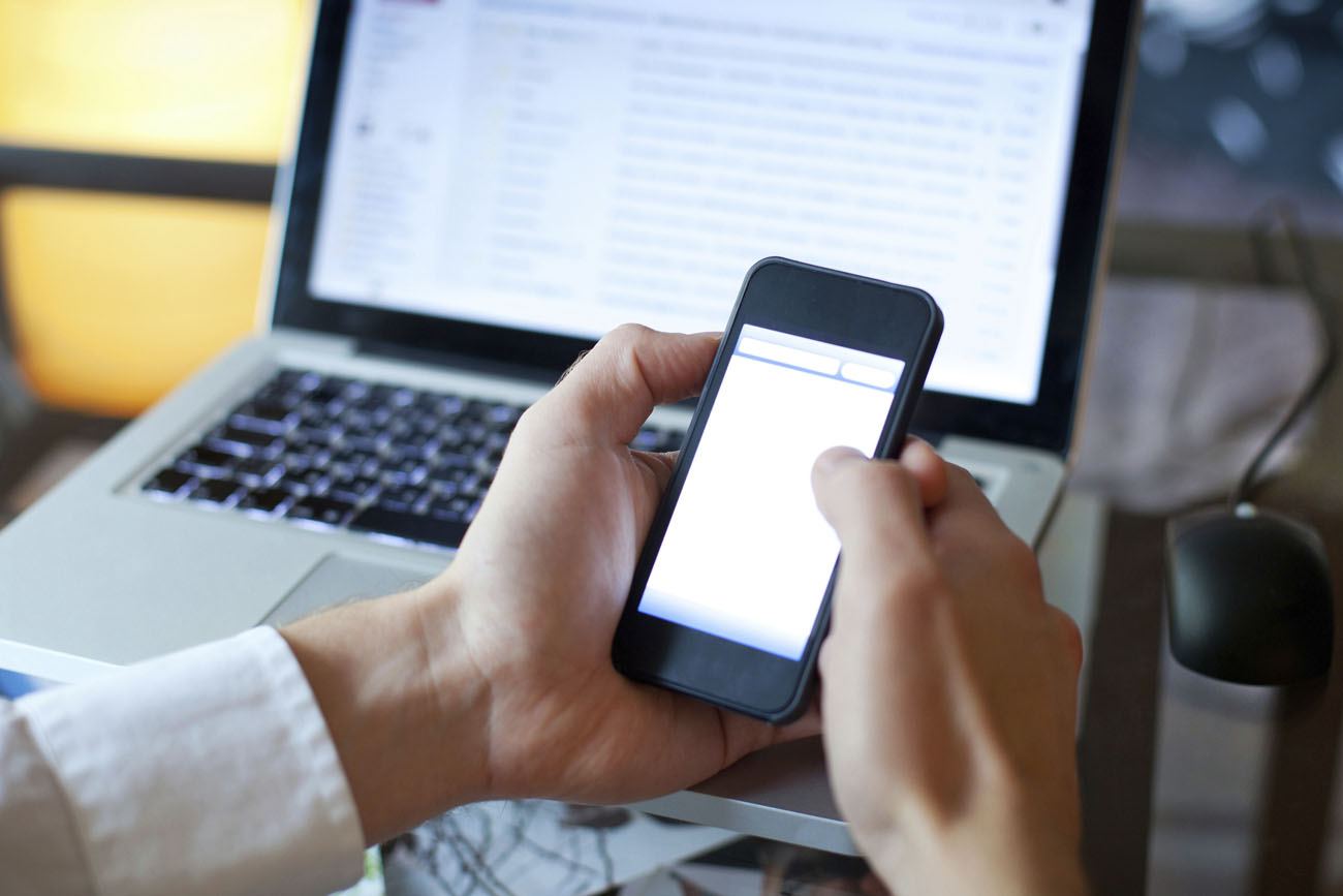 IT Services customer contacting Farnham IT support through his smartphone and laptop.